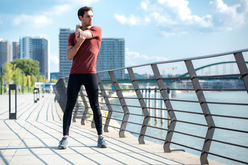 Outdoor stretching exercises, young man warming up for a workout