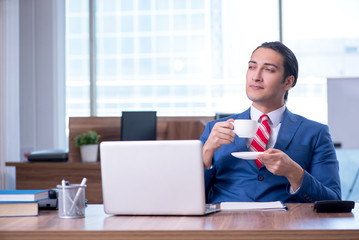 Fototapeta na wymiar Young handsome businessman sitting in the office
