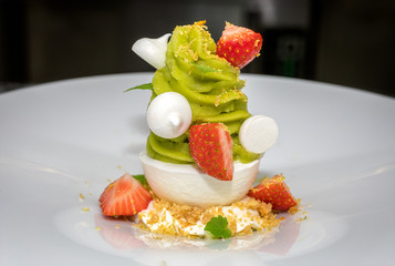 Green tea ice cream served with strawberries and mini meringues