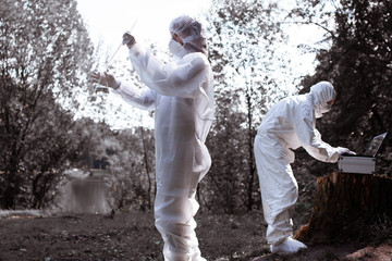 Ecological problem. Pollution. Examine soil. Scientist in protective mask and suit taking water samples from river. Chemist makes an analysis of the environment for radiation. Saving planet earth. ..