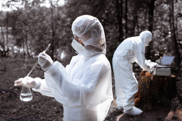 Ecological problem. Pollution. Examine soil. Scientist in protective mask and suit taking water samples from river. Chemist makes an analysis of the environment for radiation. Saving planet earth. ..