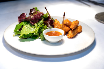Lunch plate with salad, sauce and cheese nuggets