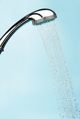 Water drops flowing from shower head in bathroom on background ,stop motion
