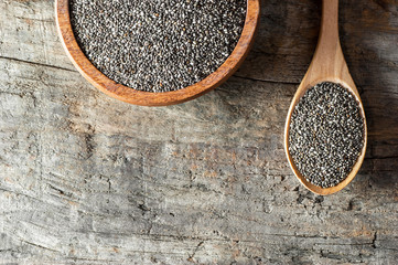 Chia seeds ( Salvia Hispanica ) in wooden spoon and bowl on wooden rustic background. Cereal...