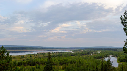 Panorama of the Bank of the vilyu river in the North of Yakutia in the spruce forest with overgrown lakes under the sky on the horizon.
