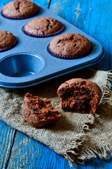Chocolate muffins on a table on the wooden back