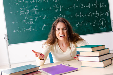 Young female math teacher in front of chalkboard
