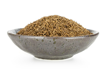 Lot of whole dry caraway fruits in a grey ceramic bowl isolated on white background