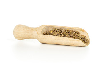 Lot of whole dry caraway fruits with wooden scoop isolated on white background