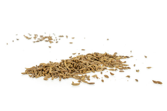 Lot of whole dry caraway fruits closeup isolated on white background