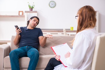 Young male patient discussing with female psychologist personal
