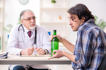 Young male alcoholic visiting old doctor