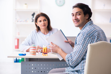 Young man visiting female doctor stomatologist