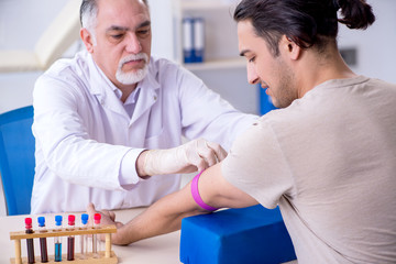 Young handsome man during blood test sampling procedure