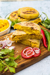 Yellow Mexican corn bread pies, tarts stuffed with sweet corn, maize kernels inside on wooden board.