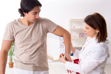 Female doctor checking patient's joint flexibility with goniometer