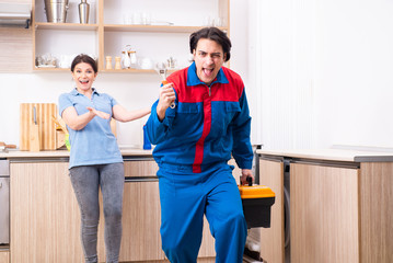 Young male repairman repairing tap