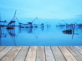 Wood table top over the dip net used for scooping fish in the sea