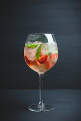Martini royale cocktail in wine glass with basil leaves and strawberry. Selective focus. Shallow depth of field.