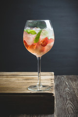 Martini royale cocktail in wine glass with basil leaves and strawberry. Selective focus. Shallow depth of field.
