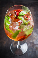 Martini royale cocktail in wine glass with basil leaves and strawberry. Selective focus. Shallow depth of field.