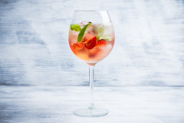 Martini royale cocktail in wine glass with basil leaves and strawberry. Selective focus. Shallow depth of field.