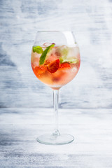 Martini royale cocktail in wine glass with basil leaves and strawberry. Selective focus. Shallow depth of field.