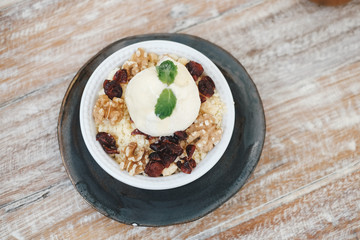 Apple crumble dessert with vanilla ice cream on the top on wooden table top view