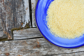 rice grains on a blue plate on a wooden surface