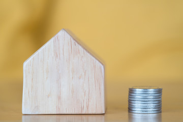 Wooden house and money coins.