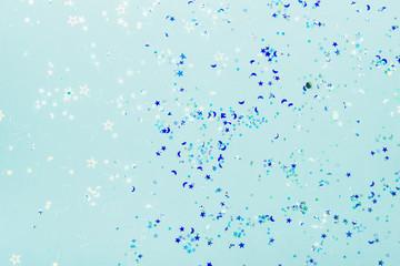 Holographic sparkles in blue neon lights. Festive trendy background