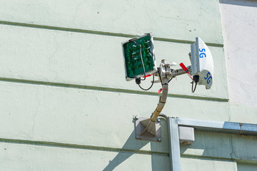Broken cellular transmitter with a broken protective cover on the wall of a building
