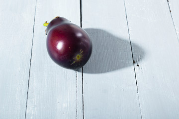 eggplant with shade on bright wood table