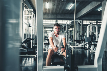 Handsome Man is Exercising With Bodybuilder Machine in Fitness Club.,Portrait of Strong Sporty Man Doing Working Out Calories Burning in Gym., Healthy and Fitness Sport Lifestyle Concept.