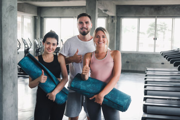 Fototapeta na wymiar Portrait of Sporty Yoga Teenagers in Sportswear at Gym Club , Group of People are Preparing for Practice Yoga With Trainer in Fitness Training Class Room, Sport and Healthy Concept.