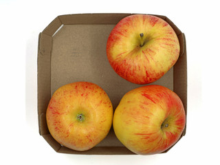 top view of three red apple inside cardboard isolated on white background