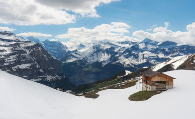 Panoramic Swiss Alps mountain range landscape with wooden cottage in Grindelwald, Switzerland 