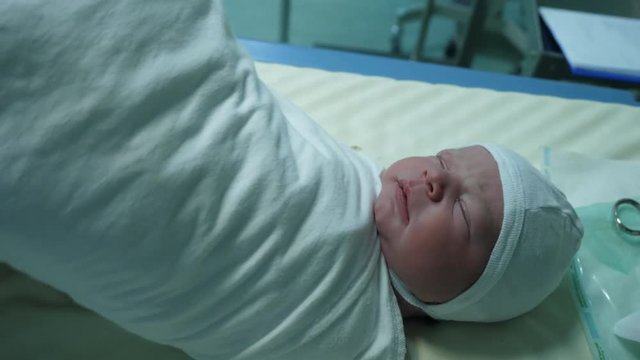 Portrait of just newborn baby child, detail of hands swaddle