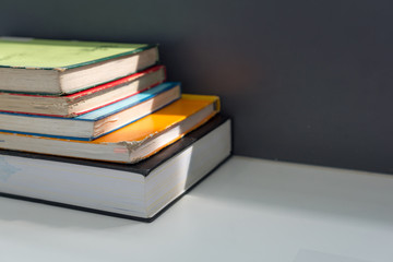 Close up books stacked on the table at the university library in selective focus.