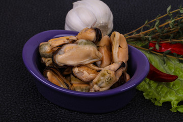 Pickled mussels in the bowl served pepper, garlic and salad