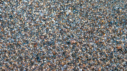 Close-up of Wet Coarse Sand. Travel Concept.