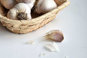 Heads and cloves of garlic in a wicker basket on a table