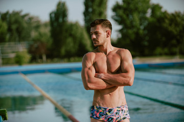 Swimmer standing next to a pool on a sunny morning