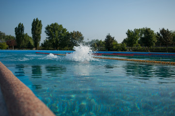 Swimmer standing next to a pool on a sunny morning