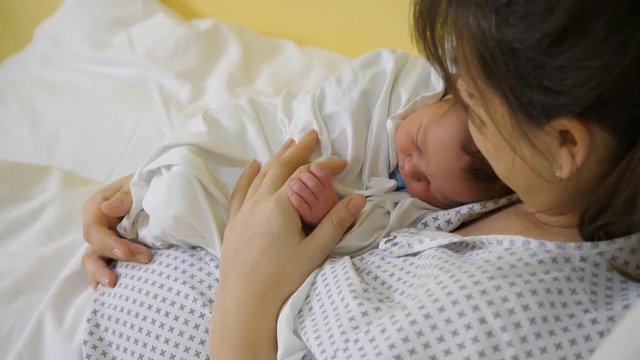 Newborn in mother arms, first moments in hospital, building attachment