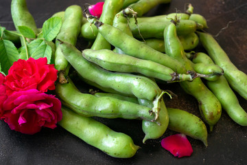 Fresh green beans of milky ripeness on the table.