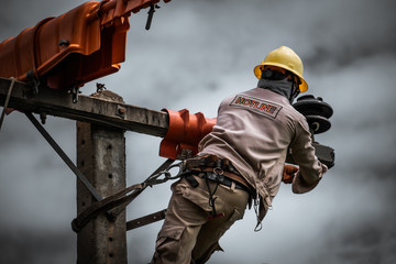 The power lineman is replacing the damaged insulator. That causes a power outage with protective...