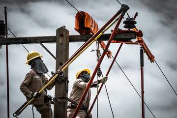 The power lineman is replacing the damaged insulator. That causes a power outage with protective equipment that is insulated and wearing personal protective equipment.