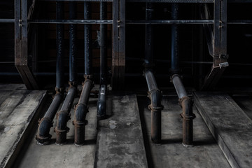 Dirty black pipes coming out of concrete wall. Texture background graphic asset.