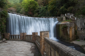 artificial waterfall in the mountain autumn forest